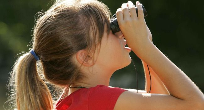 enfant observant le ciel avec une paire de jumelles