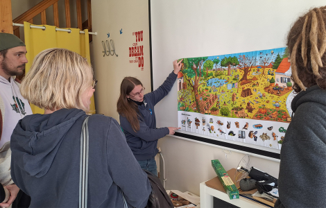 Des personnes regardent un poster qui montre la biodiversité des jardins au fil des saisons.