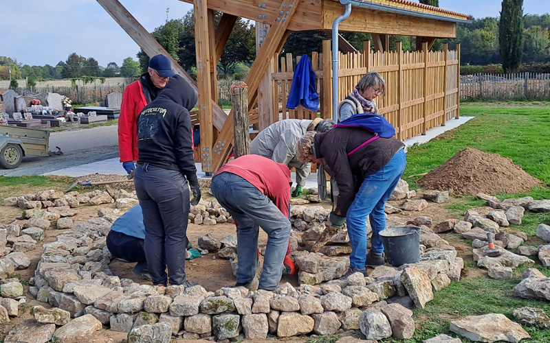Des personnes construisent un am&eacute;nagement en forme de spirale avec des pierres s&egrave;ches et de la terre pour accueillir la faune