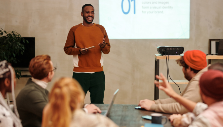Un homme présente un Powerpoint en souriant