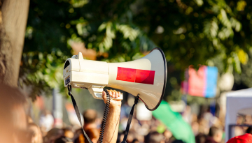photo durant une manifestation avec une main tenant un mégaphone